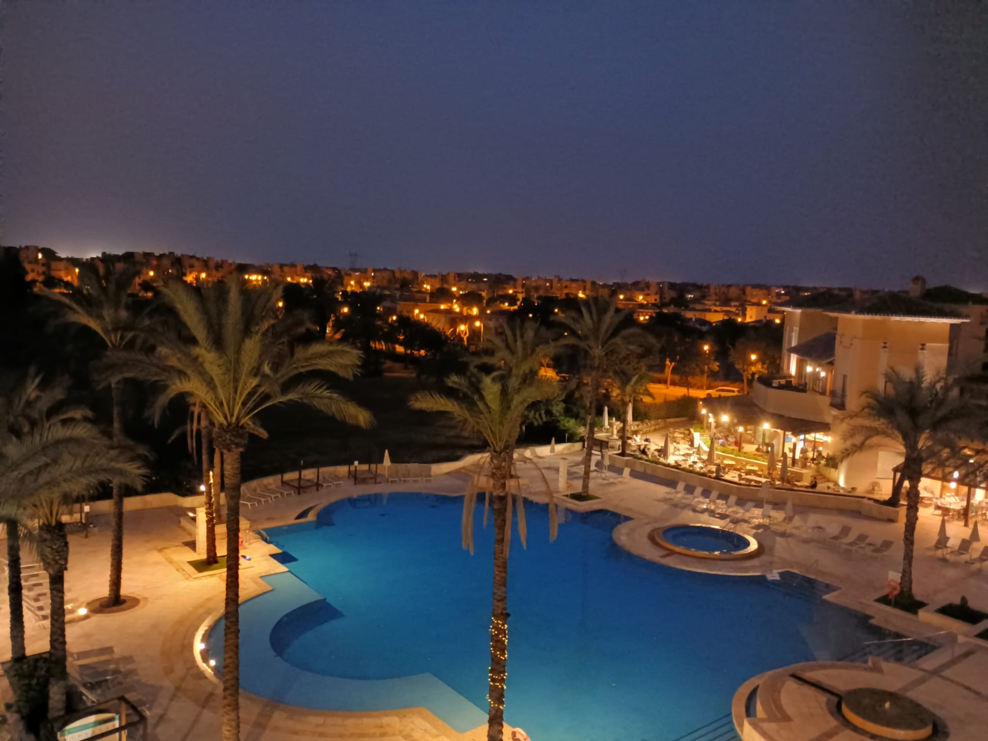 Beleuchtete Poolanlage des 5-Sterne-Resorts bei Nacht