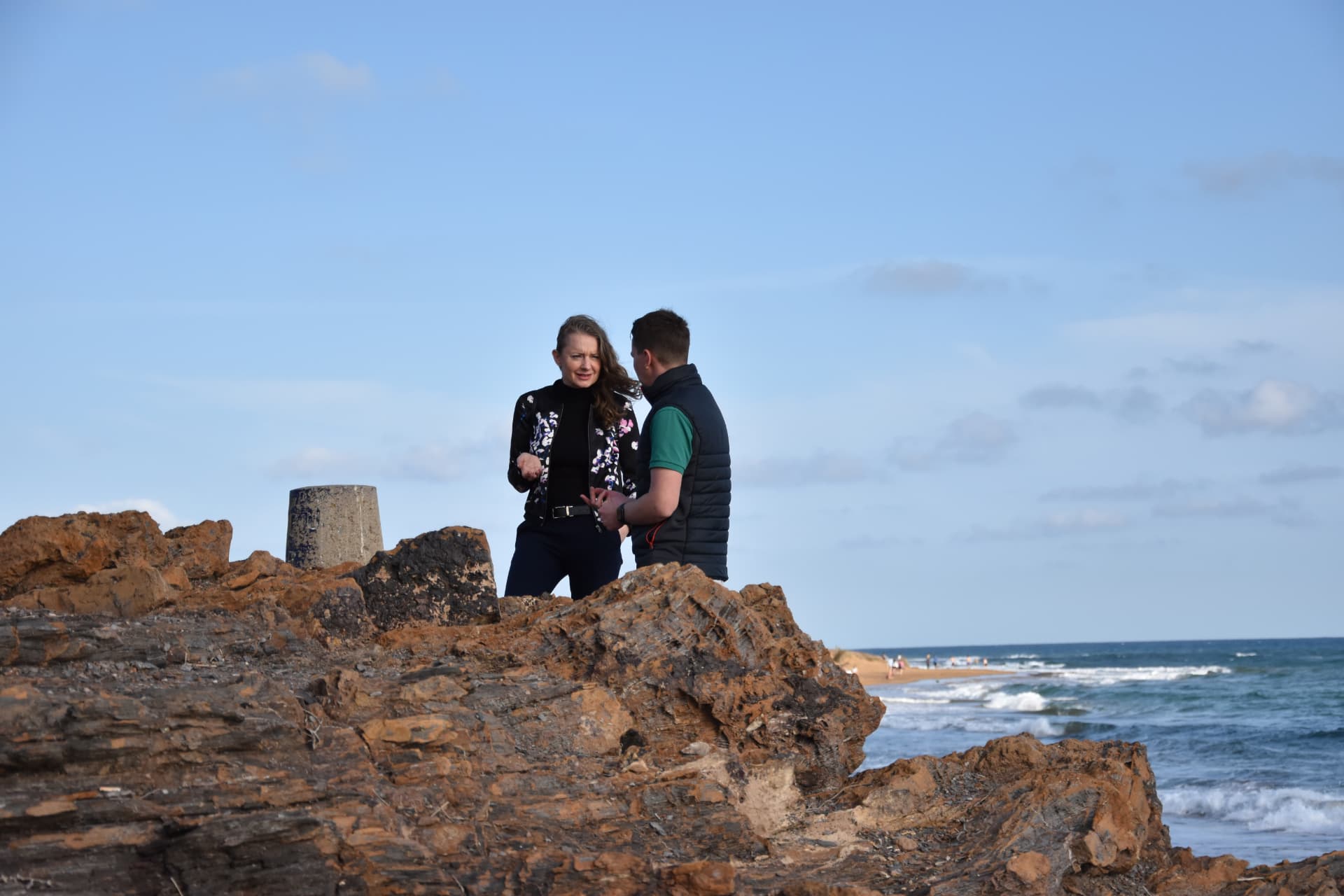 Zwei Teilnehmende im Gespräch auf den Klippen über dem Meer